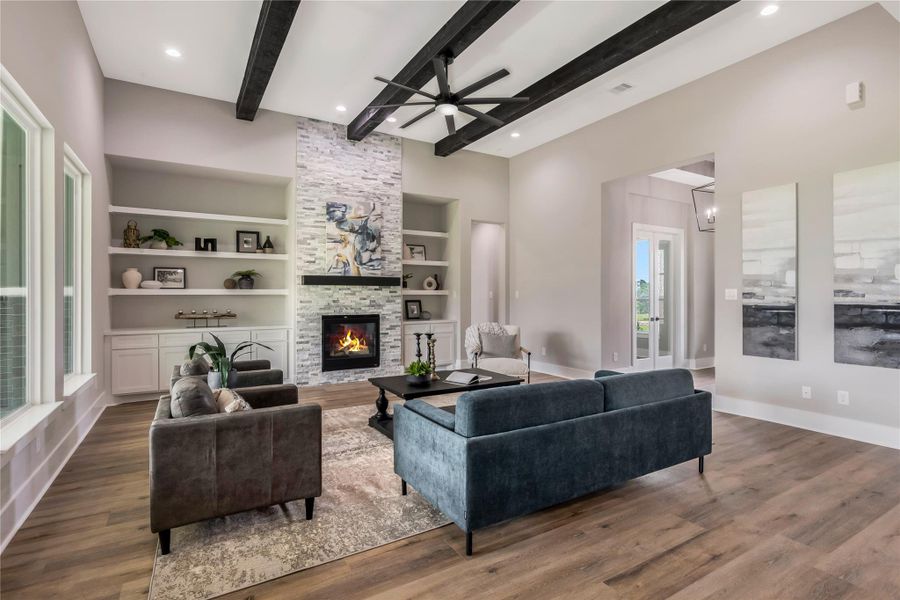 The space is accented with built-in shelving and a neutral color palette, and stone fire place The space is accented with built-in shelving and a neutral color palette, and stone fire place