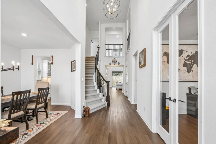 A grand two-story entryway greets visitors with an elegant curved staircase and rich hardwood flooring.