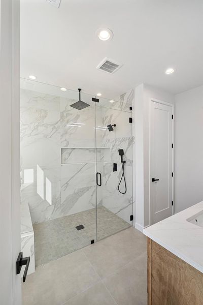 Bathroom with vanity, a marble finish shower, and recessed lighting