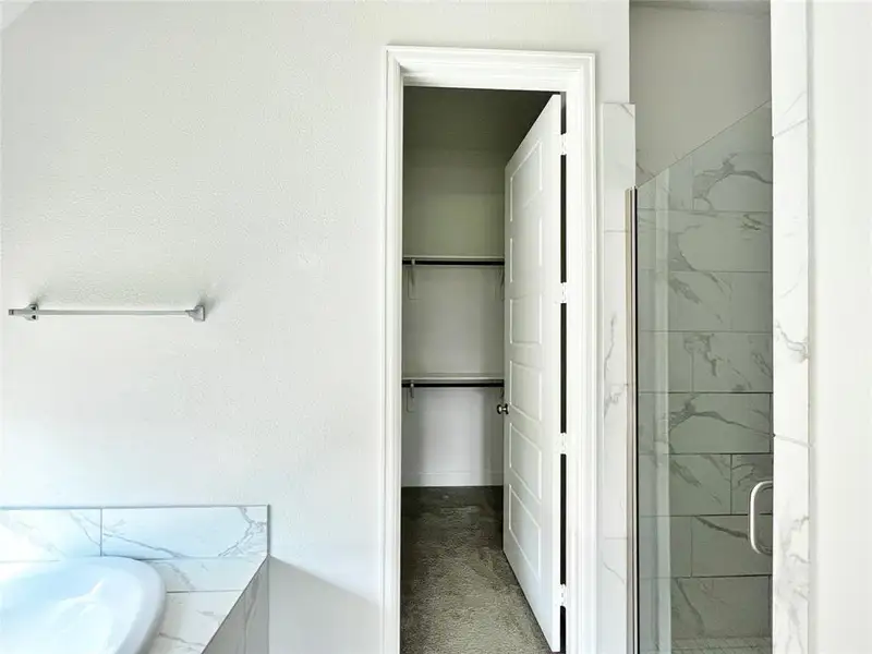 Full bathroom featuring a marble finish shower, a bath, and a walk in closet Full bathroom featuring a marble finish shower, a bath, and a walk in closet