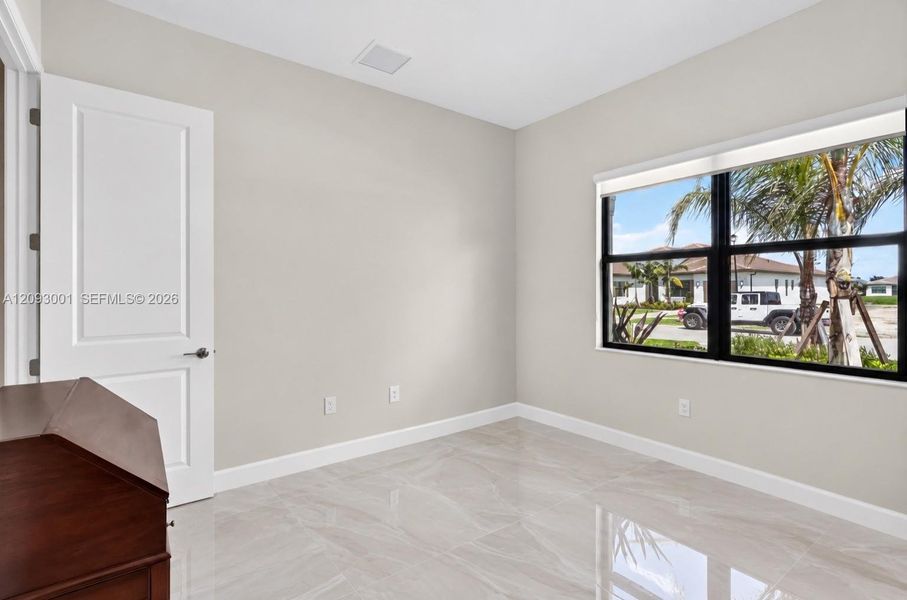 Neutral-toned walls, polished tile flooring, black-framed windows, and a solid-core paneled interior door Neutral-toned walls, polished tile flooring, black-framed windows, and a solid-core paneled interior door