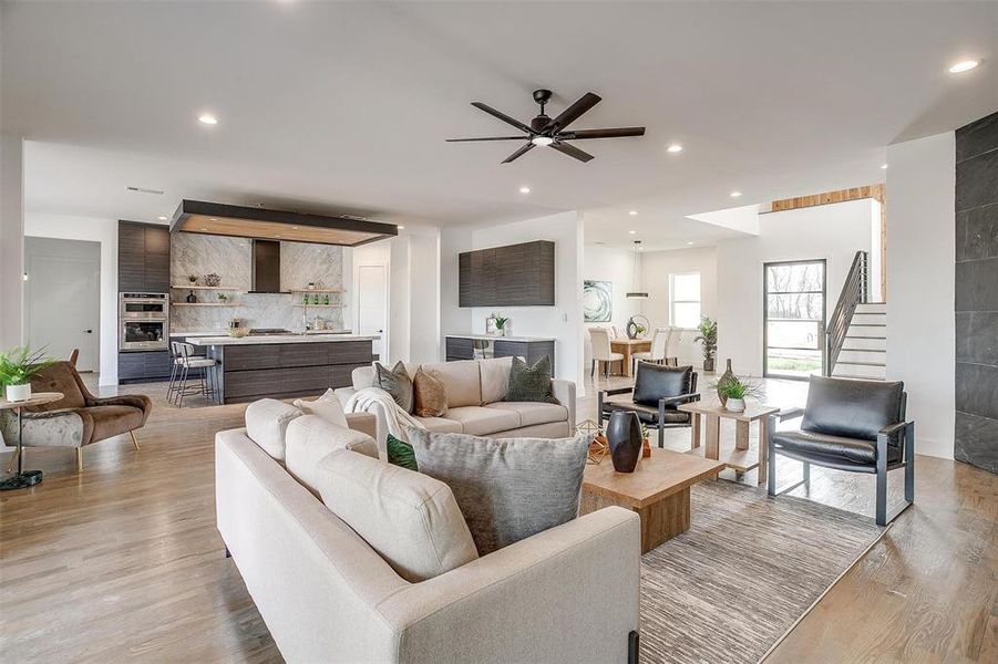 Living room with light wood-type flooring, stairway, and recessed lighting