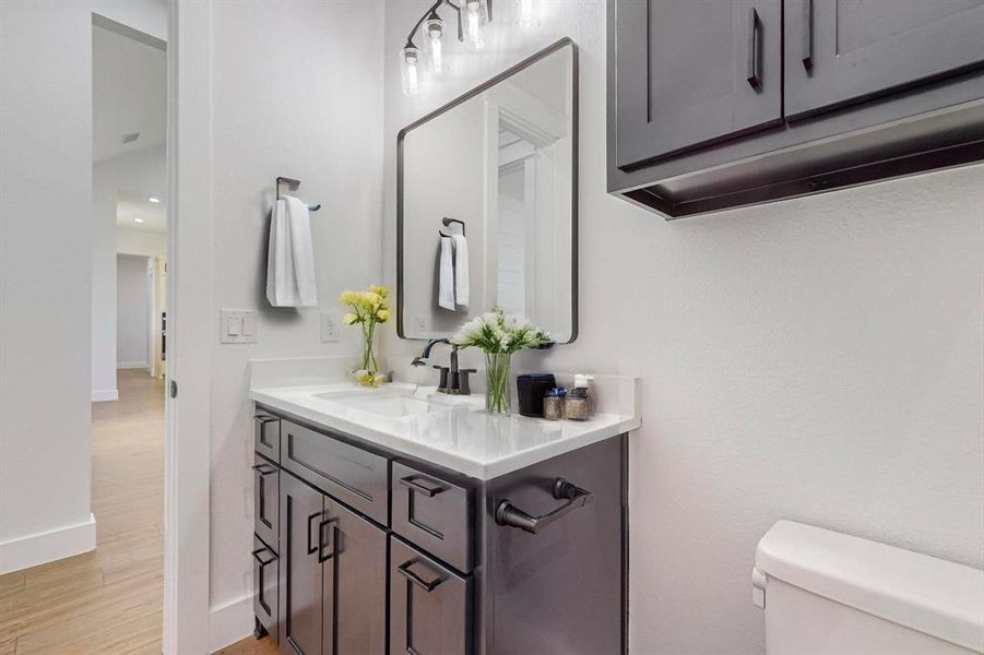 Bathroom featuring hardwood / wood-style floors, vanity, and toilet