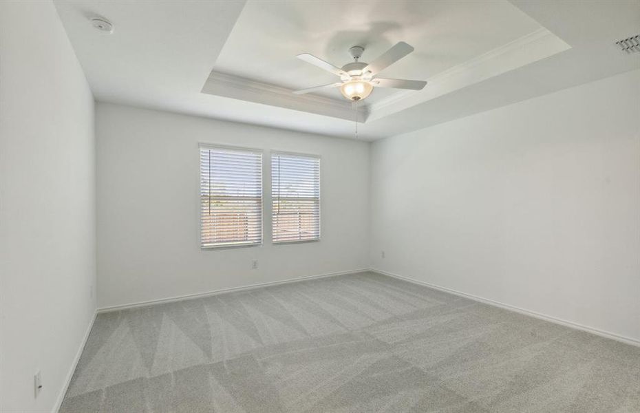 Elegant owner's suite with tray ceiling *real home pictured