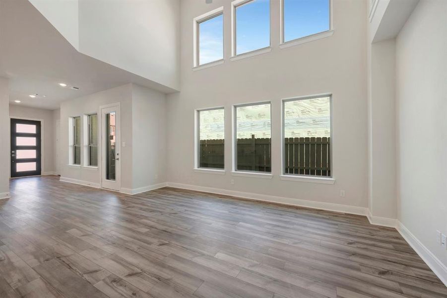 Unfurnished living room featuring dark wood finished floors and a high ceiling