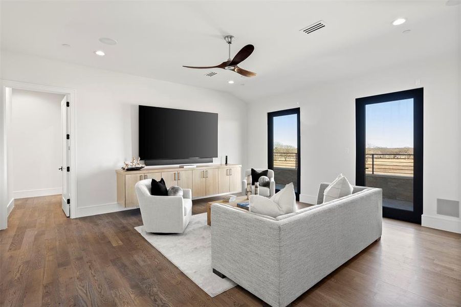 This upstairs game area features a balcony, built-in cabinet with tv and surround system.