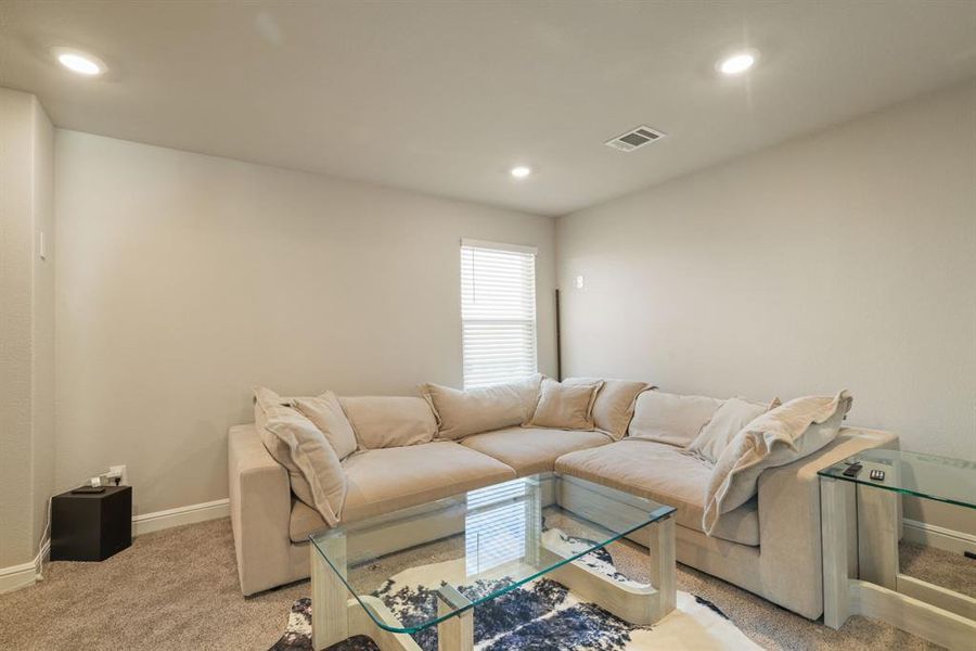 Living area with light colored carpet and recessed lighting Living area with light colored carpet and recessed lighting