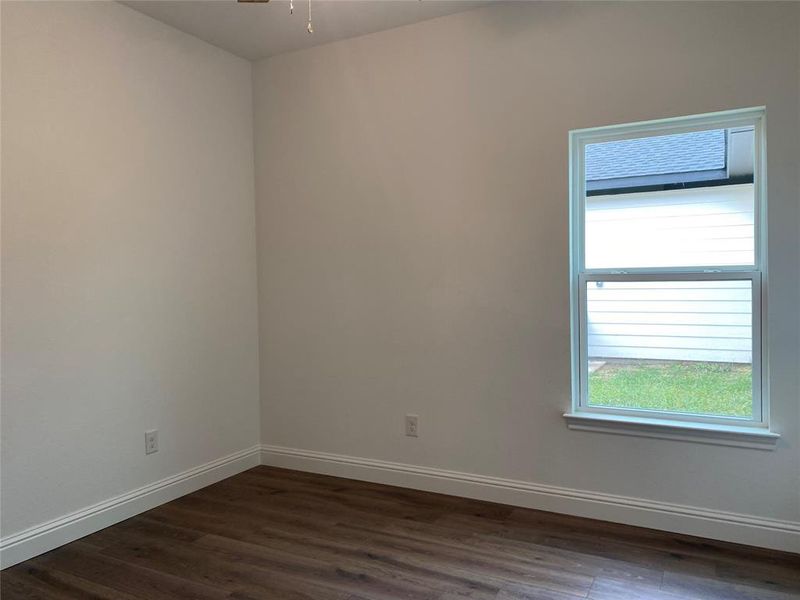 Bedroom with dark wood-style floors and a ceiling fan Bedroom with dark wood-style floors and a ceiling fan