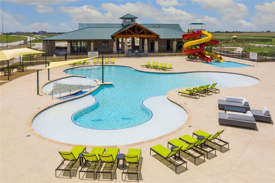 Expansive resort-style swimming pool featuring a recreational water slide, sun shelf areas, and multiple shade structures
