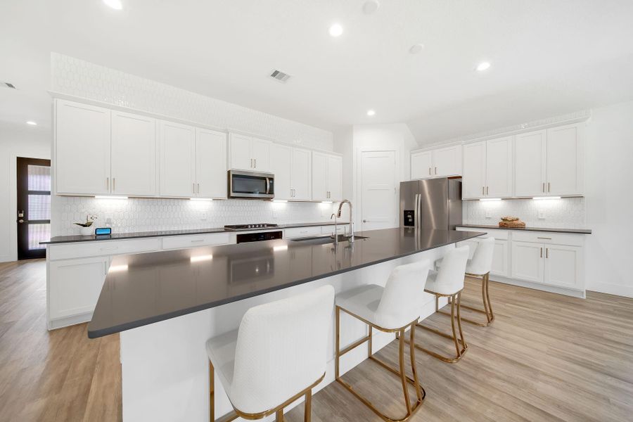 The spacious island serves as a perfect gathering spot for guests while the chef prepares meals.