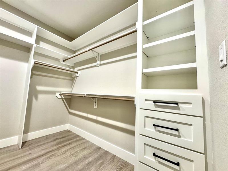 Primary bedroom closet with custom cabinetry.