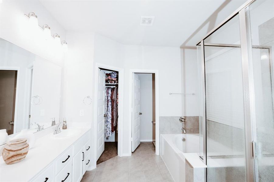 Bathroom featuring tile patterned floors, vanity, and independent shower and bath