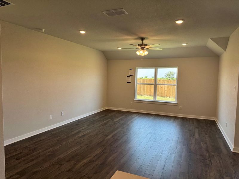 Empty room with a ceiling fan, dark wood-style flooring, recessed lighting, and lofted ceiling Empty room with a ceiling fan, dark wood-style flooring, recessed lighting, and lofted ceiling