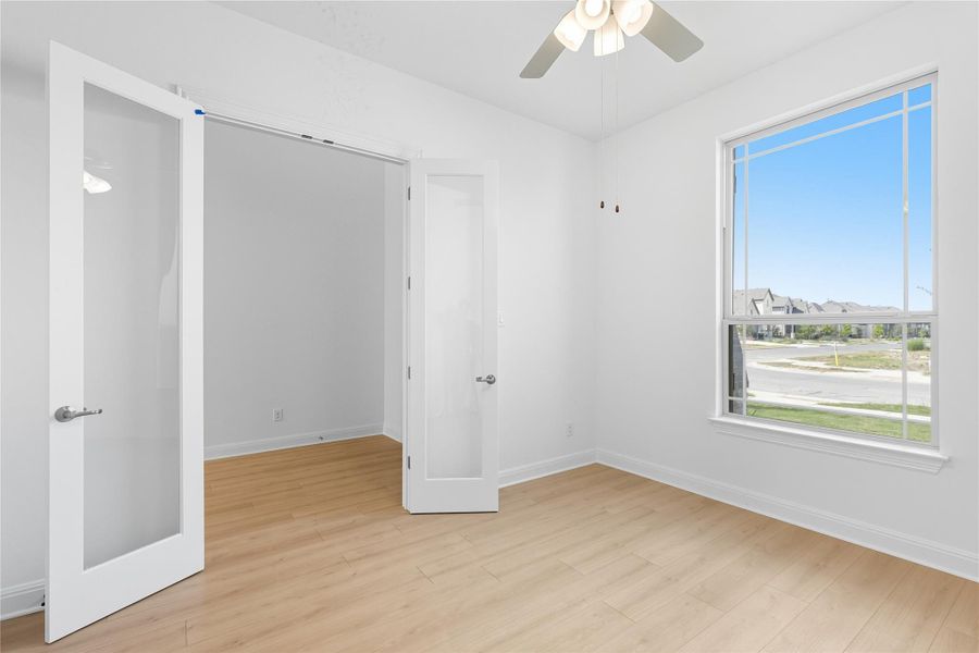 Spare room featuring light wood-style flooring, a ceiling fan, and a residential view