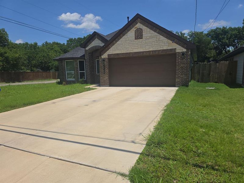 French country inspired facade featuring a garage, concrete driveway, and brick siding French country inspired facade featuring a garage, concrete driveway, and brick siding
