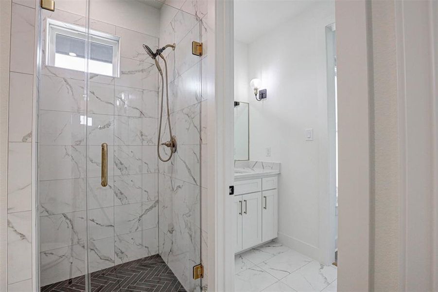 Bathroom with tile patterned flooring, a shower with door, and vanity