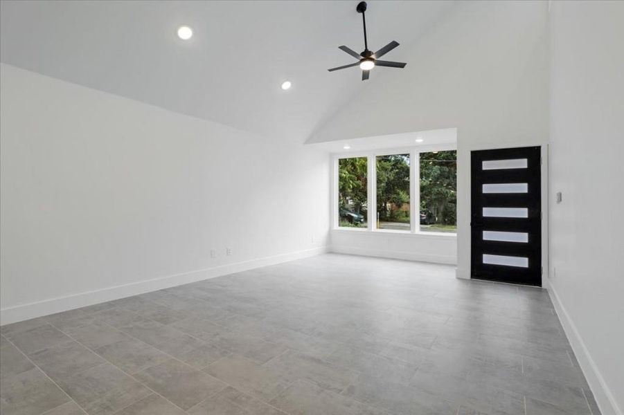 Spare room with high vaulted ceiling and ceiling fan