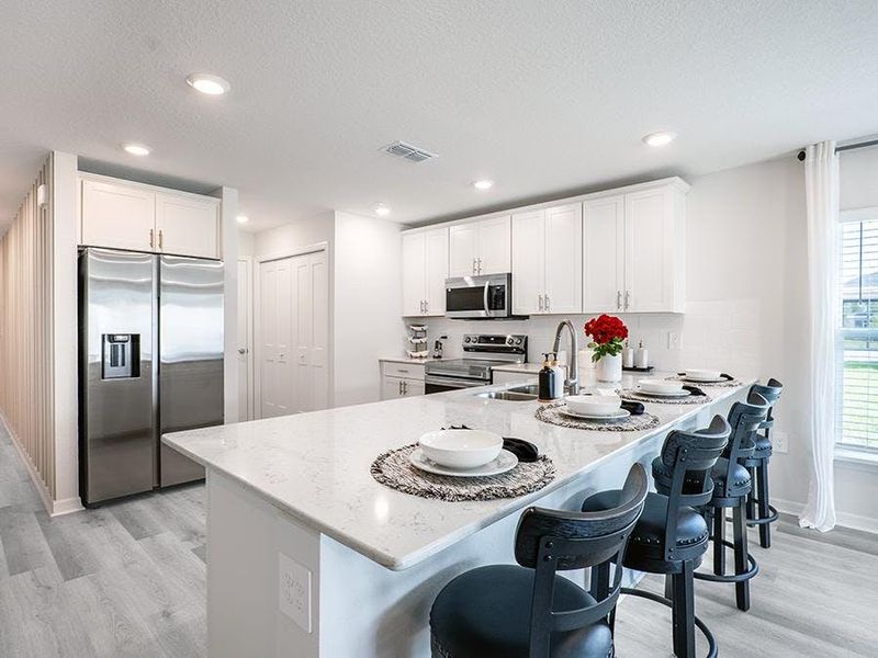 Your beautiful kitchen includes quartz and high-end finishes, along with ample cabinet space and a pantry - Daisy townhome by Highland Homes