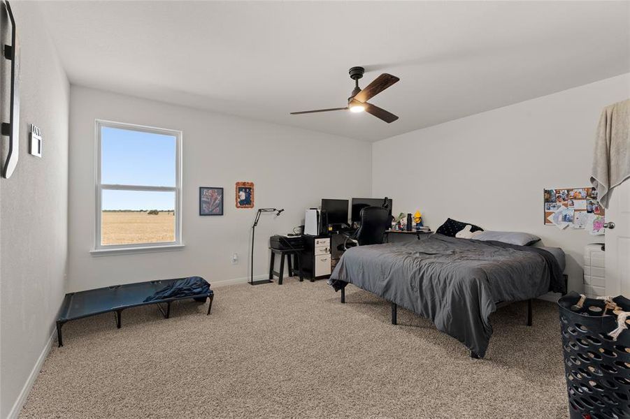 Bedroom with light carpet and a ceiling fan