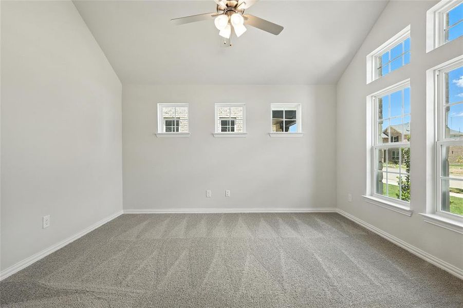 Unfurnished room with vaulted ceiling, carpet floors, and ceiling fan