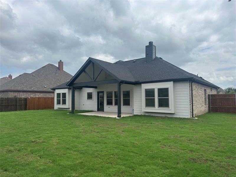 Rear view of property featuring a patio and a lawn