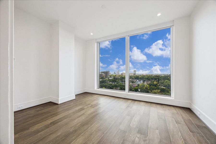 Primary bedroom with wall of window framing a spectacular view Primary bedroom with wall of window framing a spectacular view