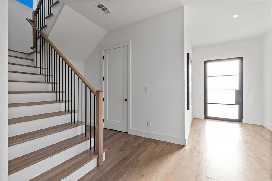 Entrance foyer featuring hardwood / wood-style flooring and lofted ceiling