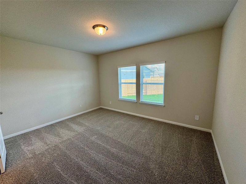Carpeted empty room featuring baseboards and a textured ceiling Carpeted empty room featuring baseboards and a textured ceiling