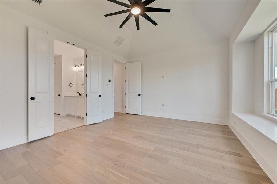 Unfurnished bedroom featuring light wood-style flooring, ceiling fan, and ensuite bath Unfurnished bedroom featuring light wood-style flooring, ceiling fan, and ensuite bath