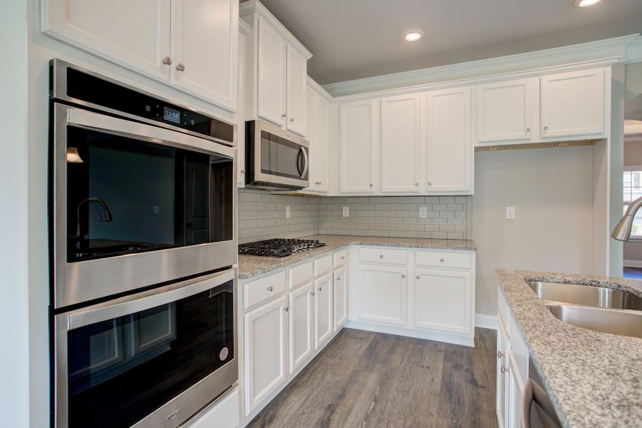 The kitchen features elegent cabinets and plenty of counter space