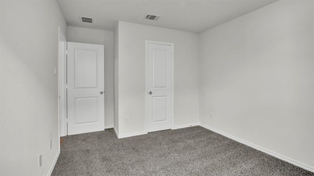 Neutral-toned room featuring a gray carpeted floor, white walls, and white trim