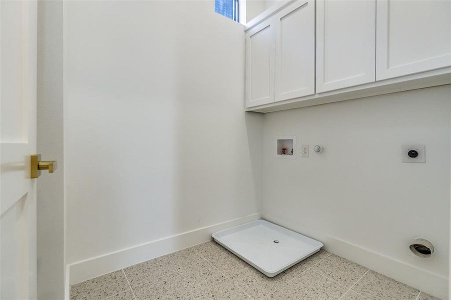 Washroom with hookup for a gas dryer, washer hookup, hookup for an electric dryer, and cabinet space