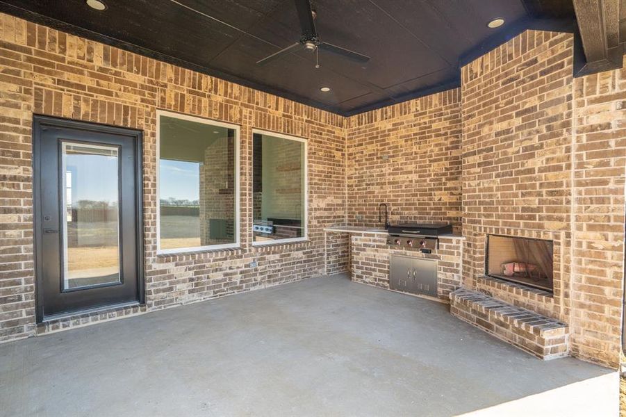 View of patio featuring ceiling fan and exterior kitchen