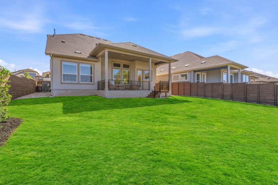 Back of property with a patio, a fenced backyard, a shingled roof, and stucco siding Back of property with a patio, a fenced backyard, a shingled roof, and stucco siding