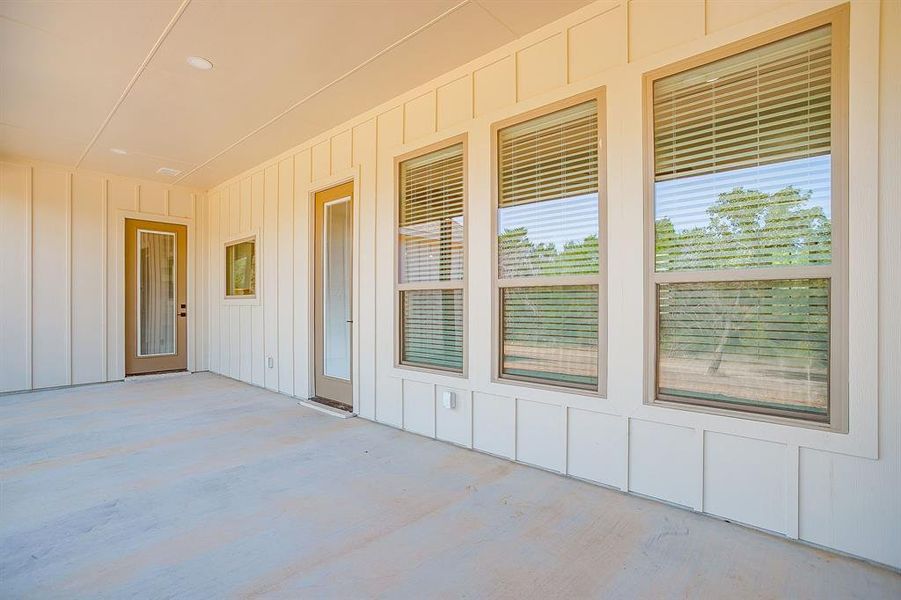 Entrance to property with board and batten siding and a patio Entrance to property with board and batten siding and a patio