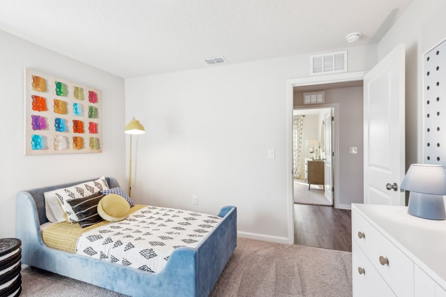 A bedroom with a bed and a lamp.