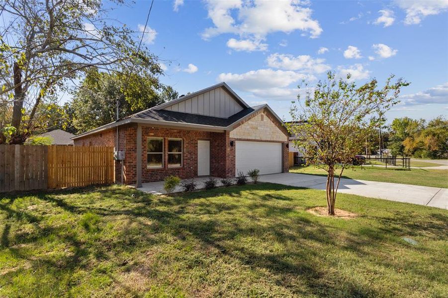 Single story home featuring concrete driveway, board and batten siding, brick siding, and an attached garage Single story home featuring concrete driveway, board and batten siding, brick siding, and an attached garage