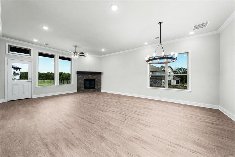 View on spacious open living and dining areas featuring a decorative gas fireplace and stained mantel. View on spacious open living and dining areas featuring a decorative gas fireplace and stained mantel.