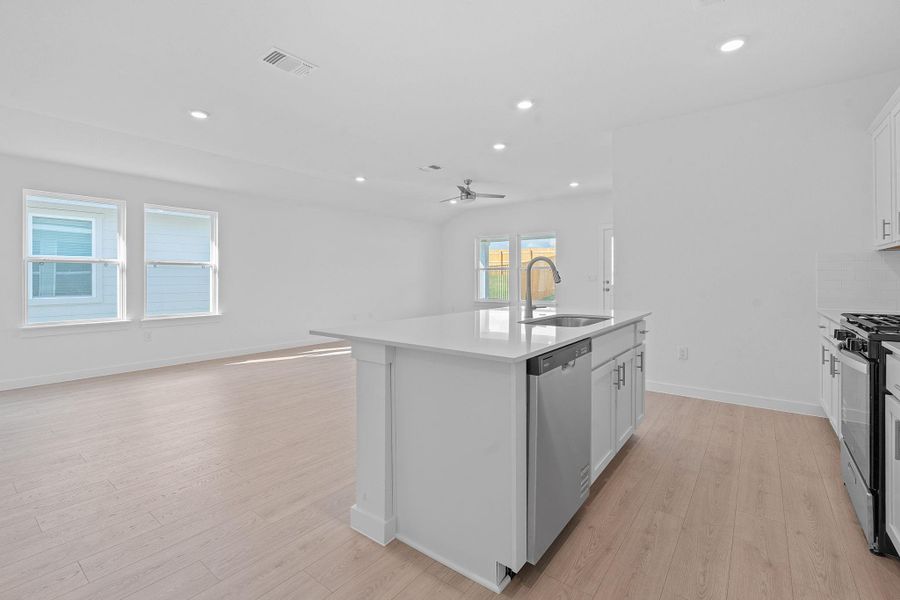 Kitchen with white cabinetry, light wood-style flooring, a kitchen island with sink, recessed lighting, and open floor plan