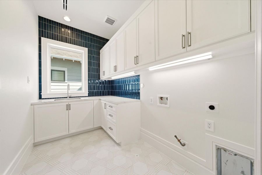 Designer utility room featuring custom cabinetry, striking blue tile backsplash, under-cabinet lighting, and generous prep space. Designer utility room featuring custom cabinetry, striking blue tile backsplash, under-cabinet lighting, and generous prep space.