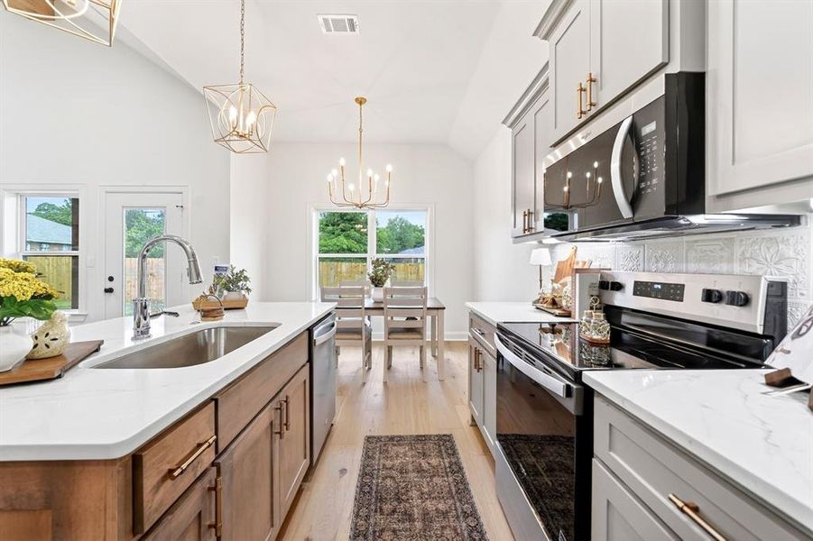 Open-concept kitchen featuring an island with a stainless steel sink and a stainless steel dishwasher