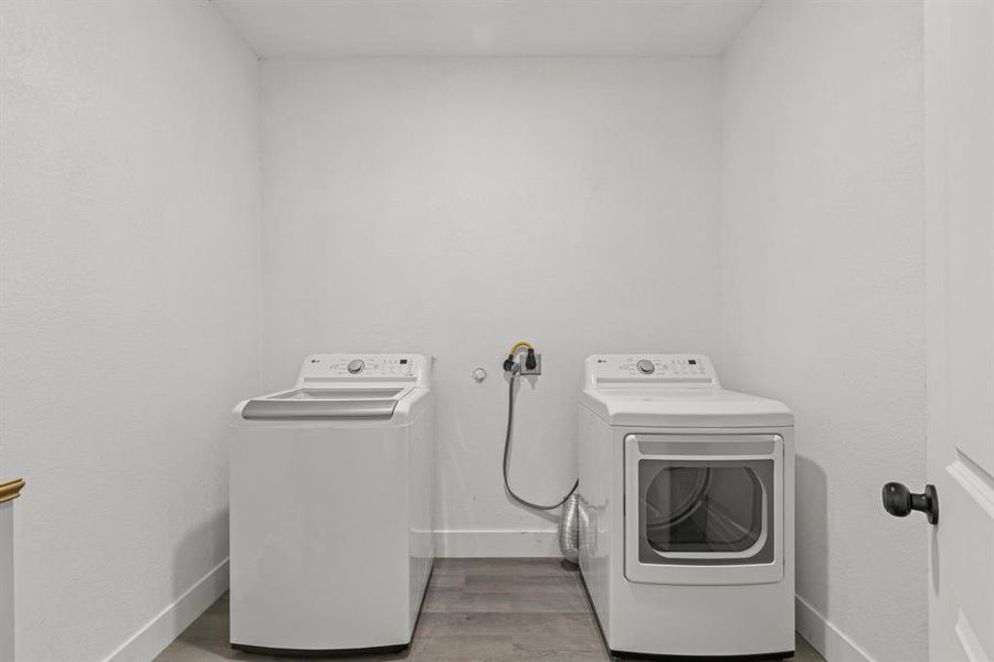 Laundry room featuring separate washer and dryer and light hardwood / wood-style floors