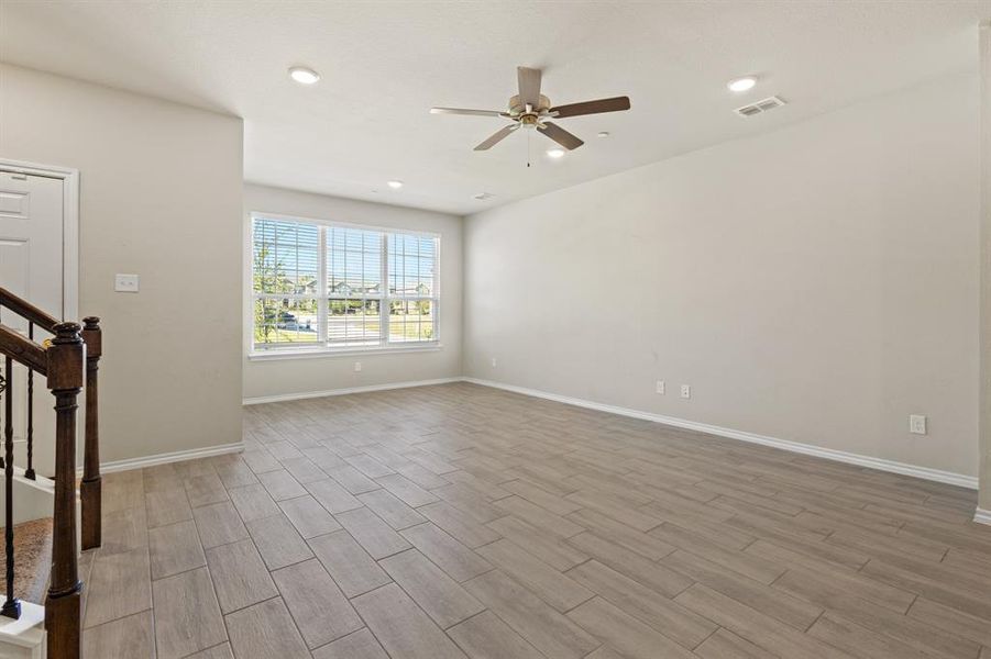 Unfurnished living room with stairs, wood tiled floors, recessed lighting, and a ceiling fan Unfurnished living room with stairs, wood tiled floors, recessed lighting, and a ceiling fan