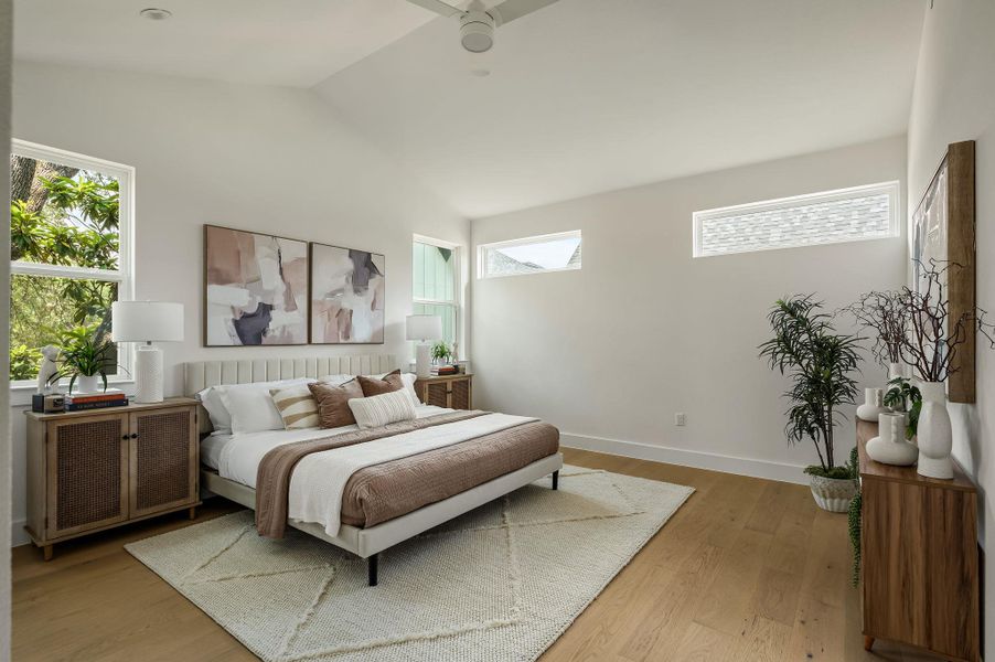 Natural light floods this spacious primary bedroom, featuring a vaulted ceiling and rich hardwood flooring. Natural light floods this spacious primary bedroom, featuring a vaulted ceiling and rich hardwood flooring.