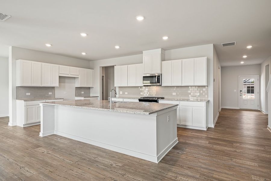 A kitchen with white cabinets.