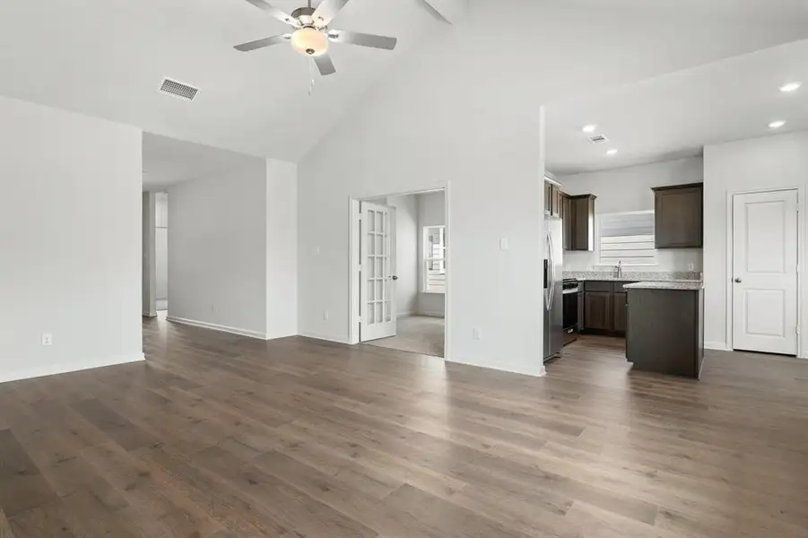 Unfurnished living room featuring high vaulted ceiling, dark wood-type flooring, ceiling fan, beam ceiling, and recessed lighting