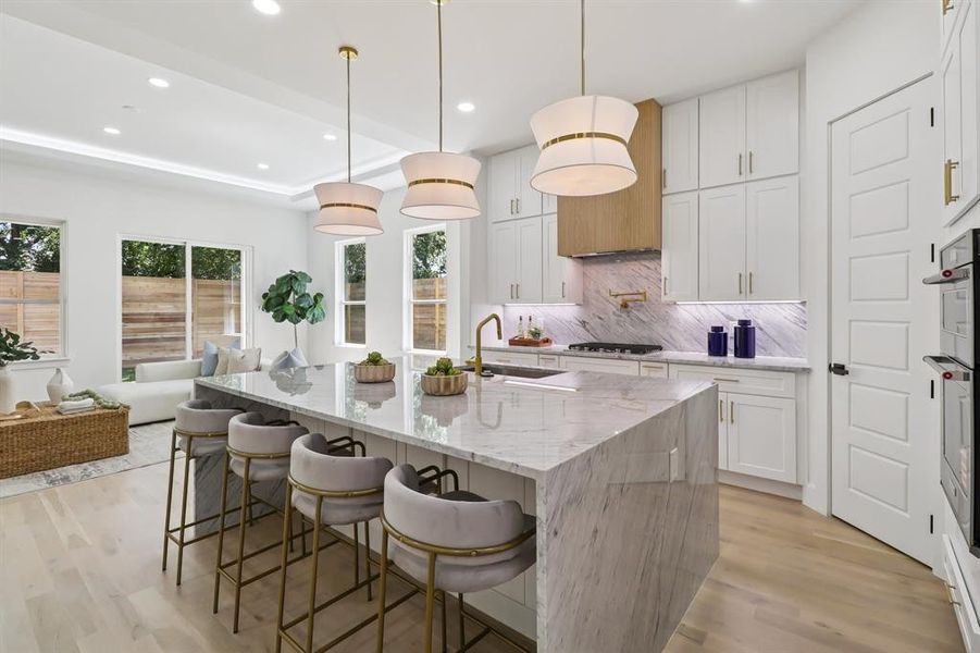 Kitchen with recessed lighting, tasteful backsplash, light wood-style floors, white cabinets, and light stone countertops