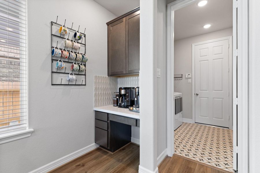 Convenient coffee bar just steps from the kitchen and entrance to laundry room with easy access to the garage.