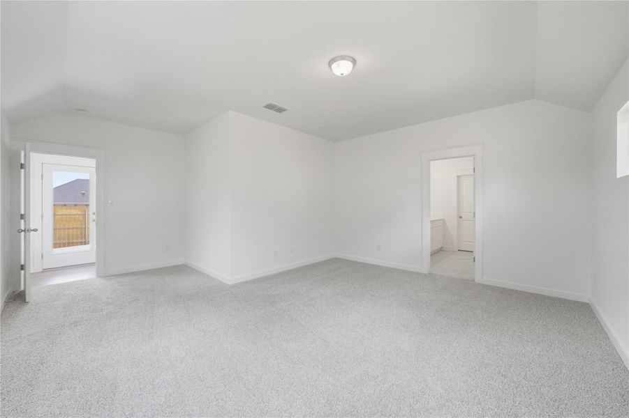 Unfurnished bedroom with vaulted ceiling, light colored carpet, and ensuite bathroom Unfurnished bedroom with vaulted ceiling, light colored carpet, and ensuite bathroom