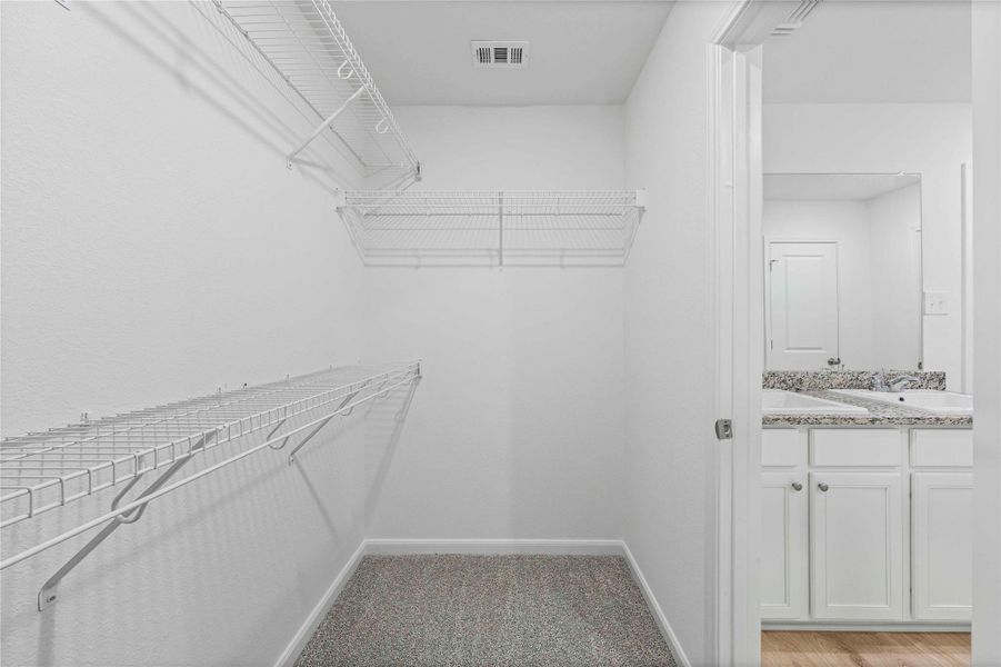 Walk-in closet space with wire shelving provides ample storage solutions.